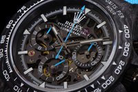 The watch in the image is a custom Rolex Cosmograph Daytona Carbon Fiber Skeleton Edition.