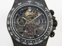 The watch in the image is a custom Rolex Cosmograph Daytona Carbon Fiber Skeleton Edition.