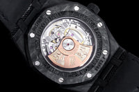 Audemars Piguet Royal Oak featuring a forged carbon fiber case and a white rubber strap.